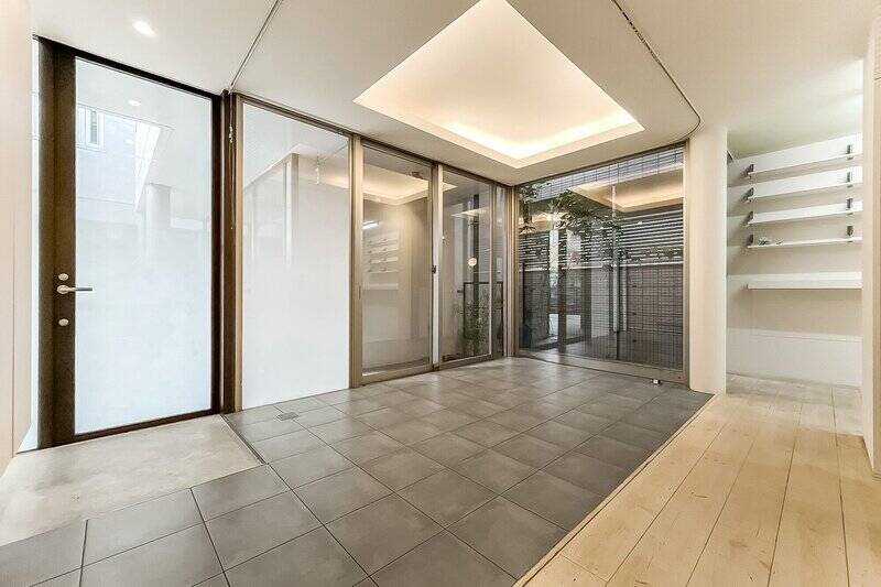 タイル敷きのスペースには床暖房を設置済み。間接照明を仕込んだ折り上げ天井で、温かみを感じます。