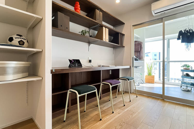 玄関の正面に見えていたふたつの空間。まずこちらは約4.1帖のワークスペースです！ 3人並んで使えるほど長いカウンターを備え、上下に収納棚とコンセント付き！