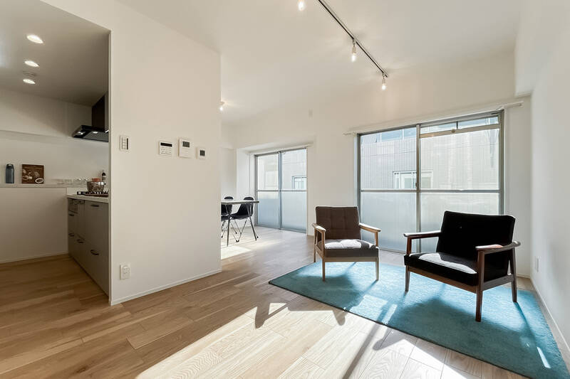 南東向きのサッシが並ぶ約14.9帖のLDK。床にはオーク材の突板フローリングが張られています。