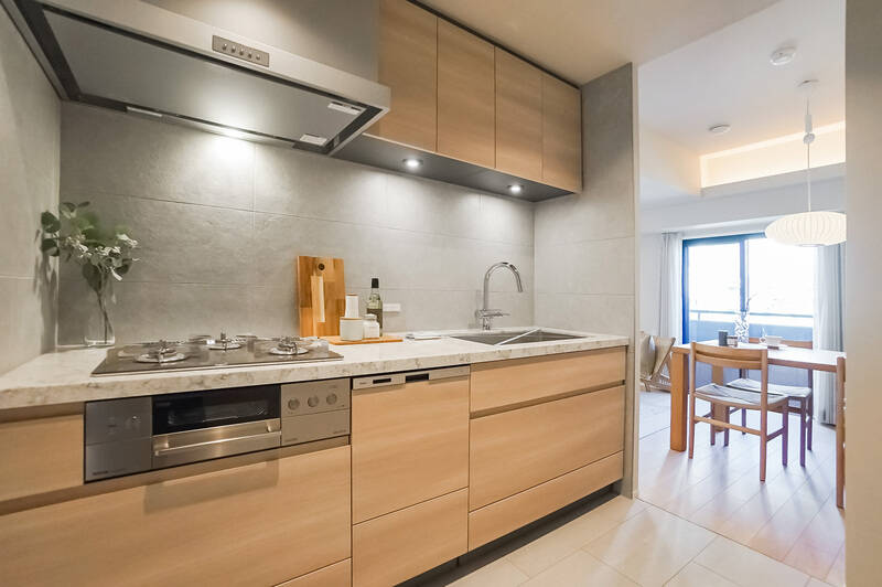 キッチンは3口コンロタイプで食洗機付き。石調のタイルがあしらわれ、ラグジュアリーな印象です。