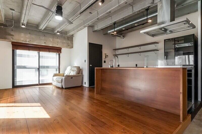 オープン型対面式キッチン。木目とステンレスの合わせ技がこの部屋の雰囲気をつくっています。背面にはウッディな素材のカップボード、オープンラックがありますよ。