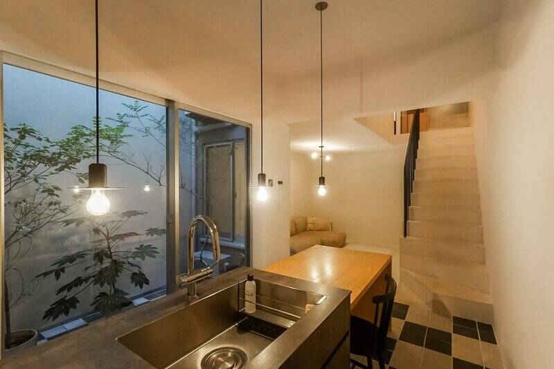 リビングとダイニングキッチン（DK）の間にある段差によって、ゆるやかにゾーニングされた空間。地下階ならではの仄暗さがムーディーな雰囲気を醸しています。