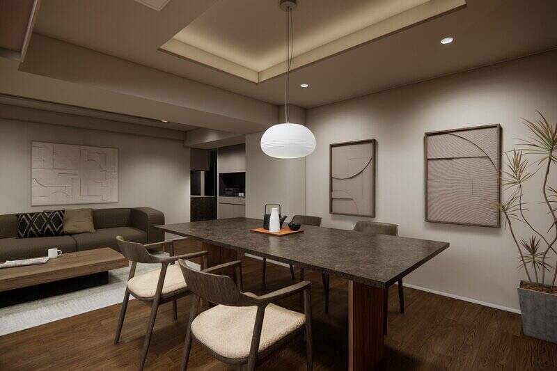 間接照明を仕込んだ折り上げ天井やダウンライトが室内をほのかに照らし、大きなアートや観葉植物が似合う空間です。整って見えるように、エアコンはカセットタイプ（天井埋め込み型）を採用しました。