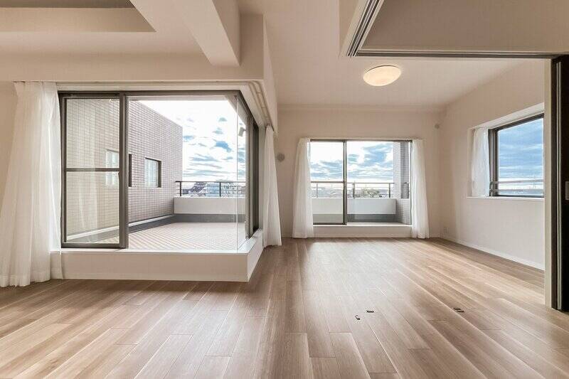 約16.6帖のLDKからスタート。南向きのコーナーサッシの先に、室内と一体的に使えそうなスカイテラスが見えています。