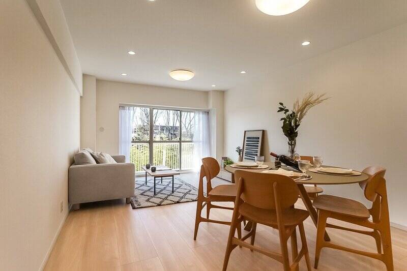 南東向きのLDKは約18.6帖。白い壁にやわらかい色のフローリング、明るくて気持ちのいい空間ですね。そしてバルコニーの向こうには緑が見える......もっと近くに行ってみましょう！