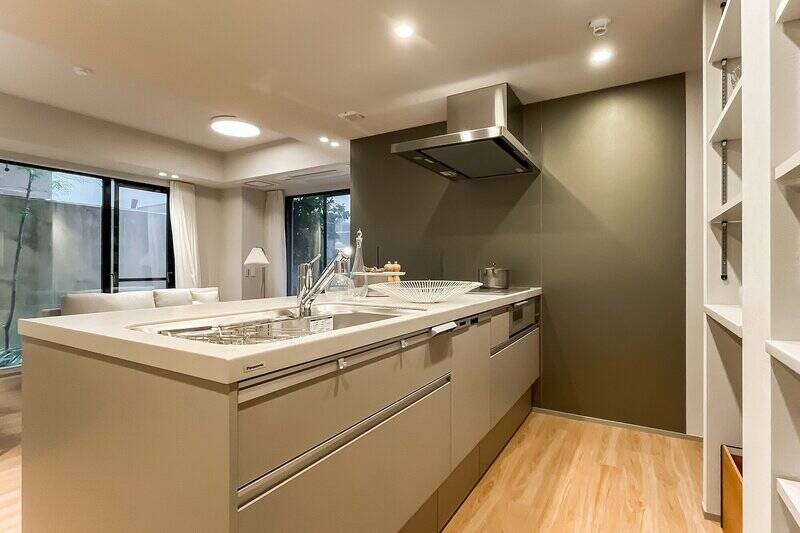 キッチンは、3口のIHクッキングヒーターと食洗機付き。背面には冷蔵庫置き場と並んで可動棚が設けられており、長期使用家電や食器の収納場所として活用できます。