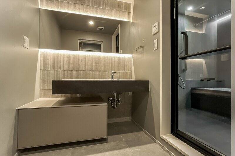 洋室Bの手前にある洗面脱衣室。シンクの天板は大理石。波打つタイルの表情がいいですね。