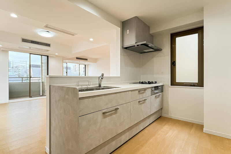 大型のシステムキッチン。吹き抜けに面した窓が付いています。