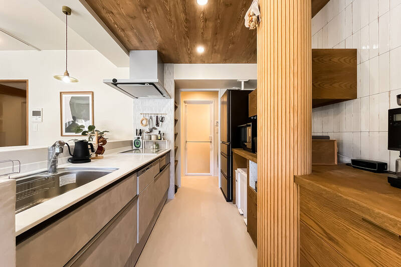 動かせないパイプスペースは円柱状に形を変え、曲面壁装材仕上げに。デザインのアクセントになっていて素敵！ 水まわりへ抜けられる回遊動線を確保しているので、家事が効率的に行えそうです。