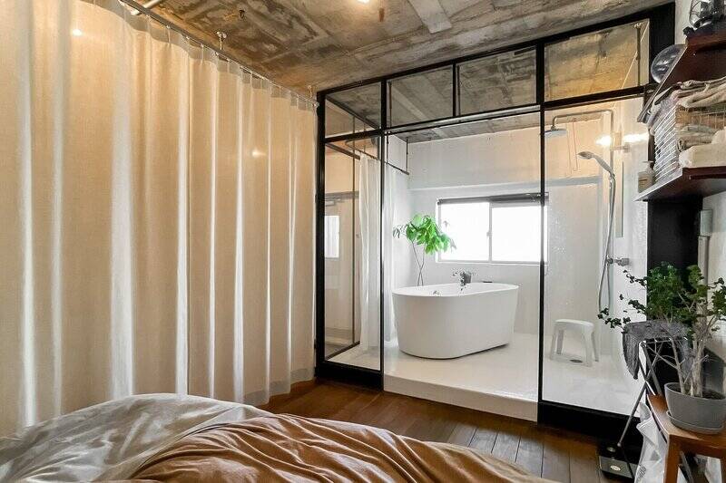 内装のアイキャッチになっているガラス張りのバスルーム。ガラスの内側にもシャワーカーテン用のレールが付いていますよ。