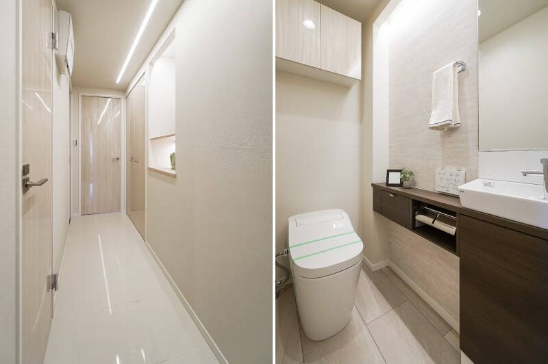 <b>左・</b>廊下はツヤのあるフロアタイルのおかげで明るい印象に。壁面に設けられたディスプレイカウンターの隣には、システム収納が備わっています。廊下にも収納があるのはポイント高いですね。／<b>右・</b>トイレは小さな手洗い器付きです。