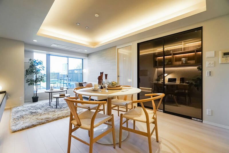 LDKは約15.4帖。オフホワイトを基調とした品のいい内装で、間接照明や鏡面仕上げの建具がほんのりラグジュアリーなムードを醸し出しています。