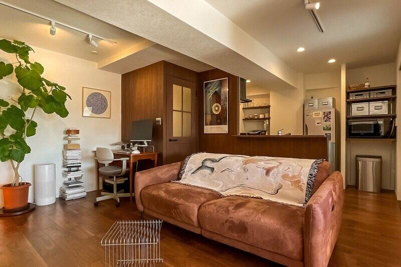 対面キッチンの周辺は、建具と同じ色味の木製パネルで空間のアクセントに。