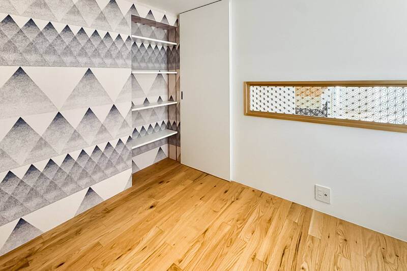 壁の一面にはアクセントクロスが貼られています。写真中央の扉はリビングへ出入りすることができます。