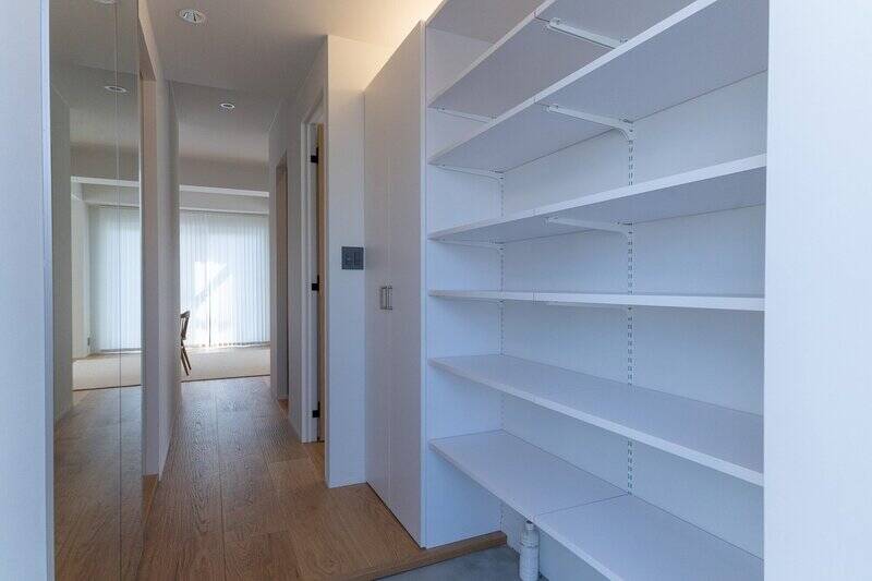 玄関扉を開けると、右手には大きなシューズボックスと扉付きの収納が。突き当たりのLDKはあえて建具を設けておらず、洗練された空間が広がっています。