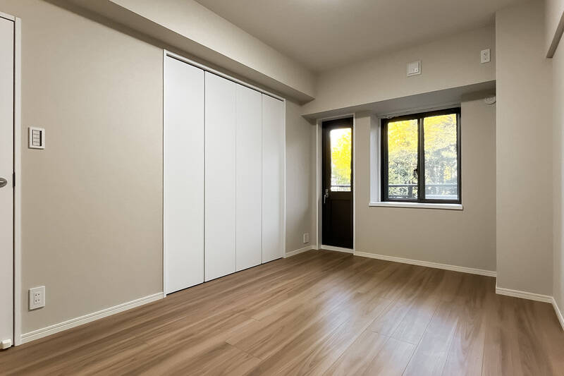 側面にクローゼットが付いた居室です。出窓のほか、黒いドアがありますね。開けてみましょう！