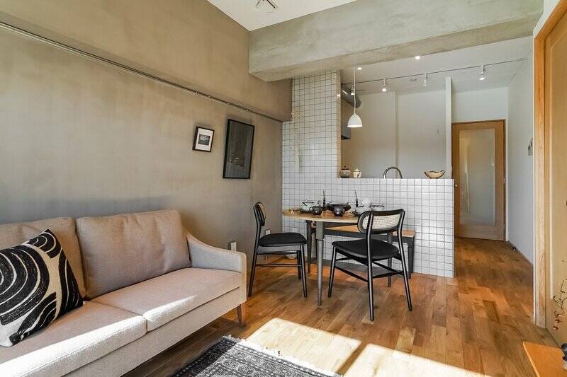 写真左手の壁面には、調湿・消臭性に優れた天然素材のシリカライム塗装がアクセントで施されています。壁紙とは異なる味が出るのが塗り壁の推しポイント♡ キッチンの腰壁は全面タイル貼りで、LDKの顔になっています。