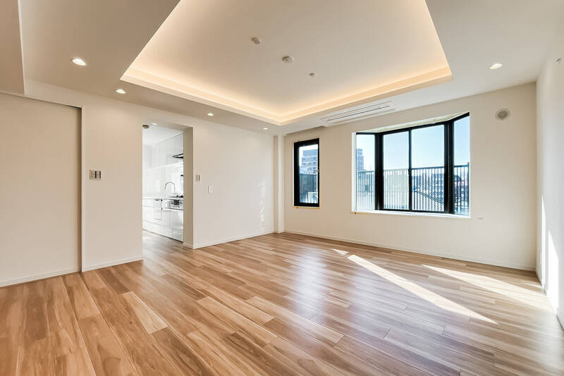 南西向きの2つの窓から光が差し込む、約22.8帖のLDK。折り上げ天井が空間に奥行きをもたらし、内側に仕込まれた間接照明がやさしい雰囲気を演出します。