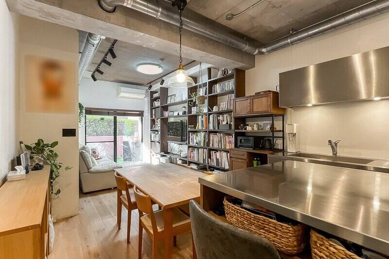 躯体現しの天井、排気ダクトや鉄管、ステンレス製キッチンなどソリッドな要素の中に、フローリングや造作棚の木が温もりをプラスしています。