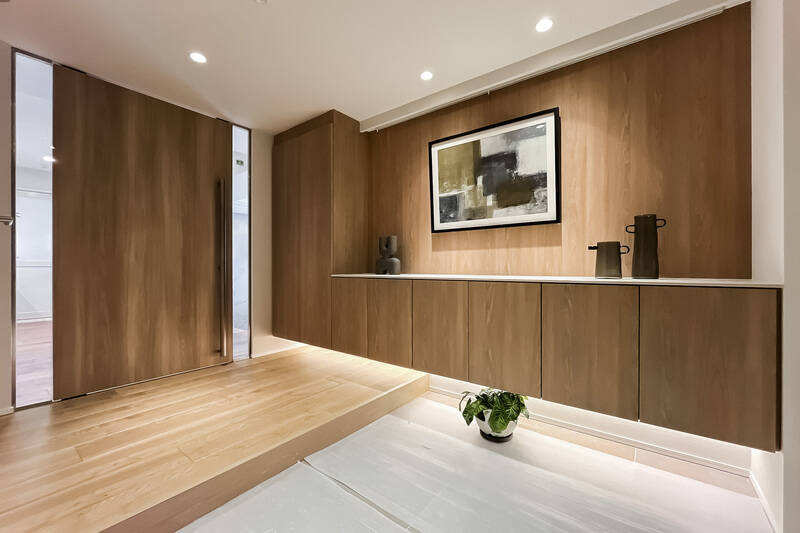 広々とした玄関ホール。フロータイプの下足入れと収納は間接照明で足元を照らし、板張りの壁面上部にはピクチャーレール。両側にガラススリットの入った大きな扉を押し開け、LDKへ参りましょう。