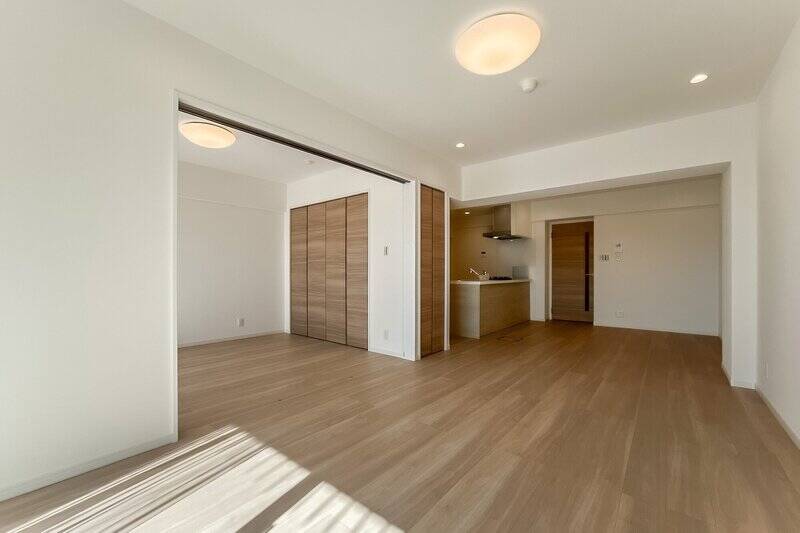 白と木で構成されたシンプルな内装。中央にはリビング収納が設けられています。