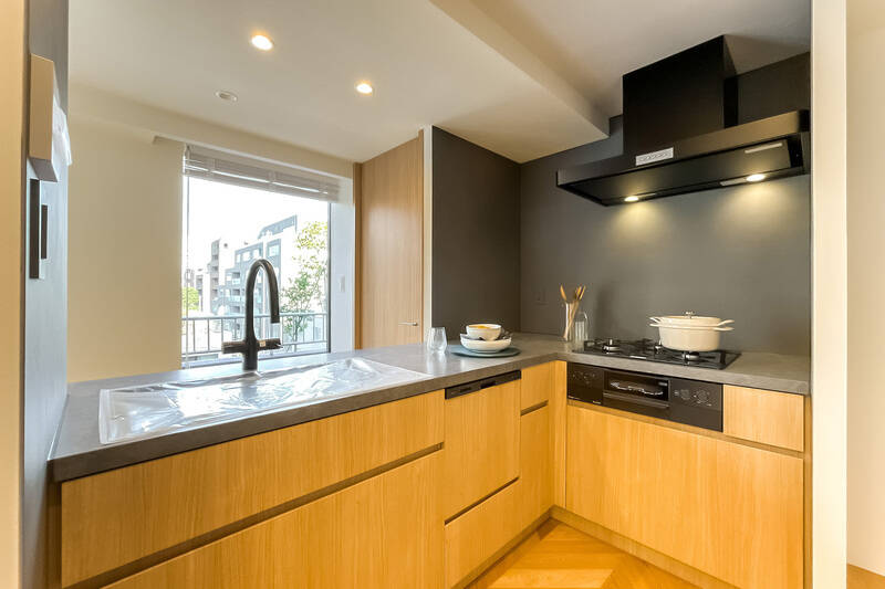 通路を挟んで大きな掃き出し窓がに面しているため開放的。食洗機に3口ガスコンロ、グリルを搭載。