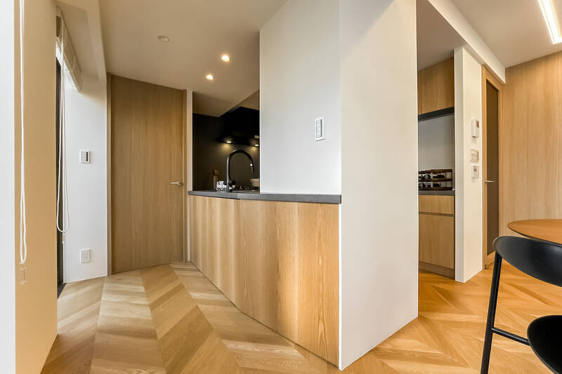 キッチン腰壁も木目調で統一され、全体のインテリアが調和しています。