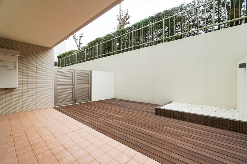 フロアタイル敷きのテラスと、ウッドデッキのジェントルコート（専用庭）は合わせて約41.6㎡の広さ。右手奥は玉砂利を敷き詰めた植込みエリアです。