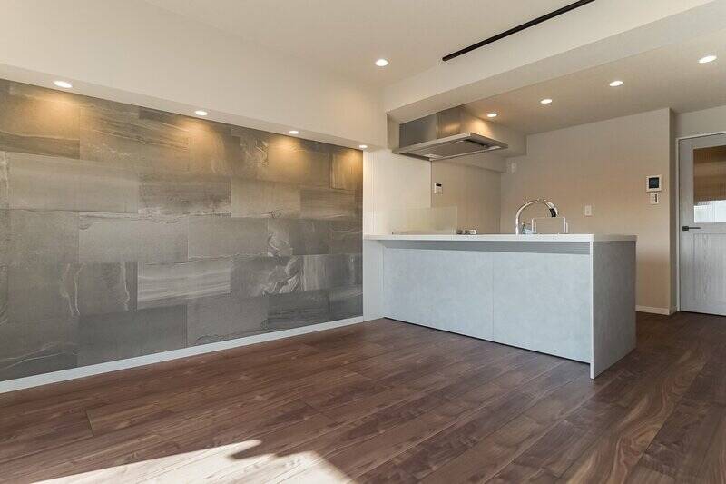 リビングダイニングの壁一面は、アクセントとして石調のグレーに。キッチンや建具のトーンと合っていて素敵ですね。