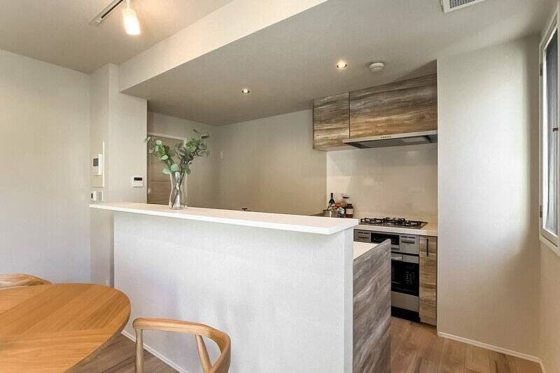 キッチンはカウンター付きで、生活感がでやすいキッチンまわりが見えづらい造り。左奥にある扉から廊下にアクセスでき、扉の向かいには洗面室が位置しているので、家事動線もスムーズ◎