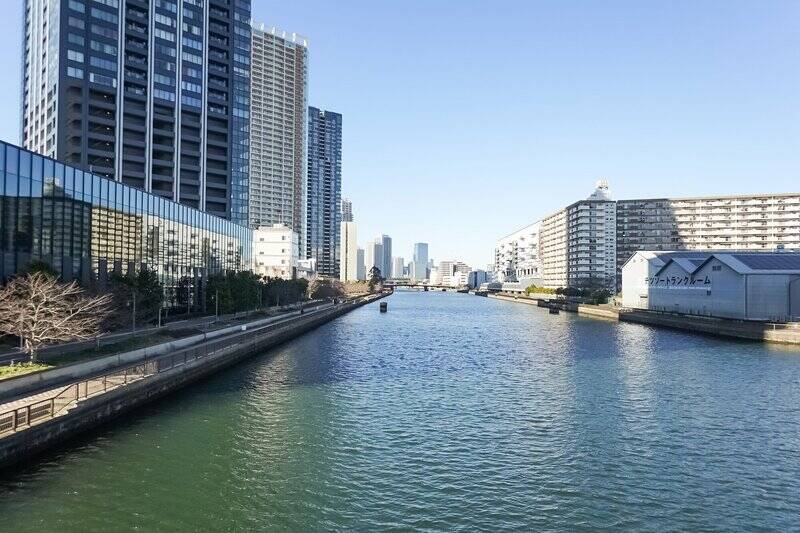 本日は、たおやかに流れる「豊洲運河」に来ております。そして今回訪問するマンションの姿は、すでに右手にありまして……