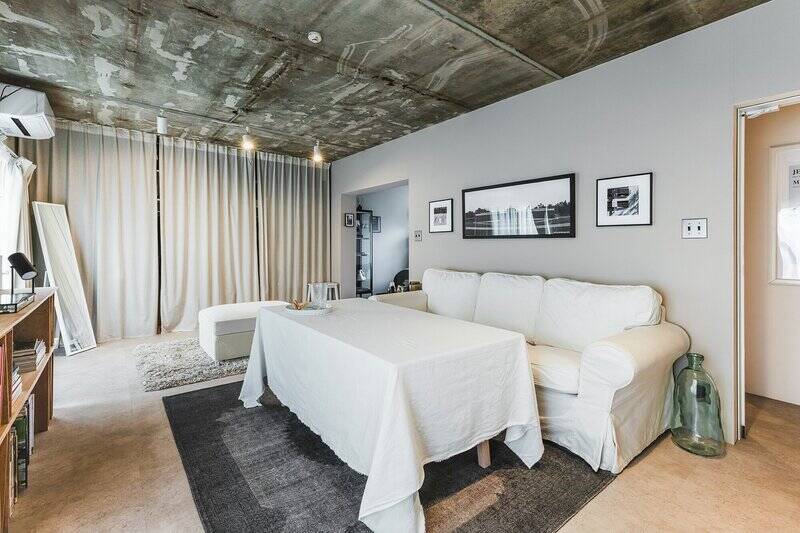 リビングは約11帖。躯体現し天井、塗装壁、グレーの床で、インダストリアル感のある空間になっています。