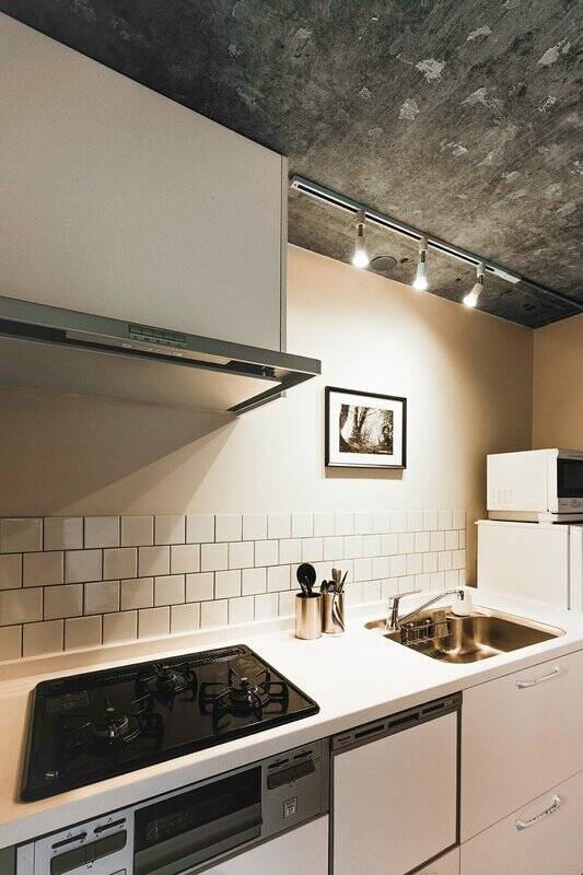 キッチンは3口コンロ、グリル、食洗機付き。壁面にはタイルが貼られています。