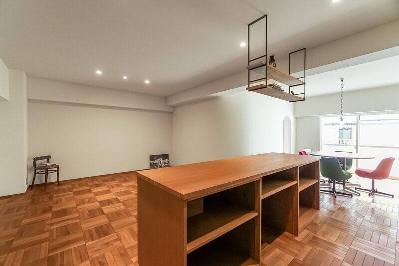 こちらはマンション2階に所在している南西向きの2SLDK。木製のカウンターを中心に、リビングとダイニングそれぞれの空間が緩やかにゾーニングされています。LDKの広さは約23帖です。