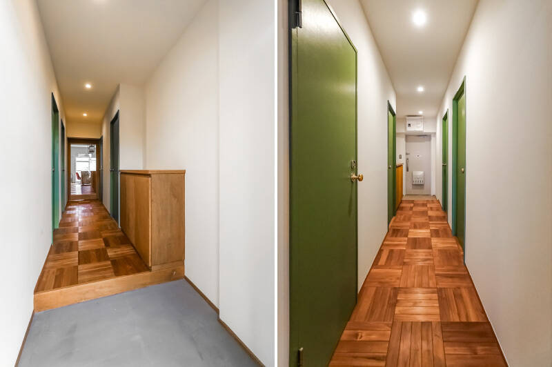 むむ！ 入った瞬間にわかる、天然素材のしっとりした気配……モルタル仕上げの土間に、壁や天井は白塗装。LDKへ伸びる廊下は、ちょっと珍しいパーケット（寄木模様）フローリングじゃあないですか！ レトロ感あるグリーンのドアも可愛いですね。