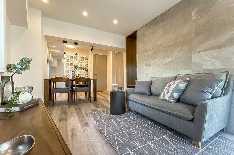 リビングスペースの壁は石調のタイル仕上げで、梁(はり)に設置されたライティングレールが空間にアクセントを添えるデザインに。