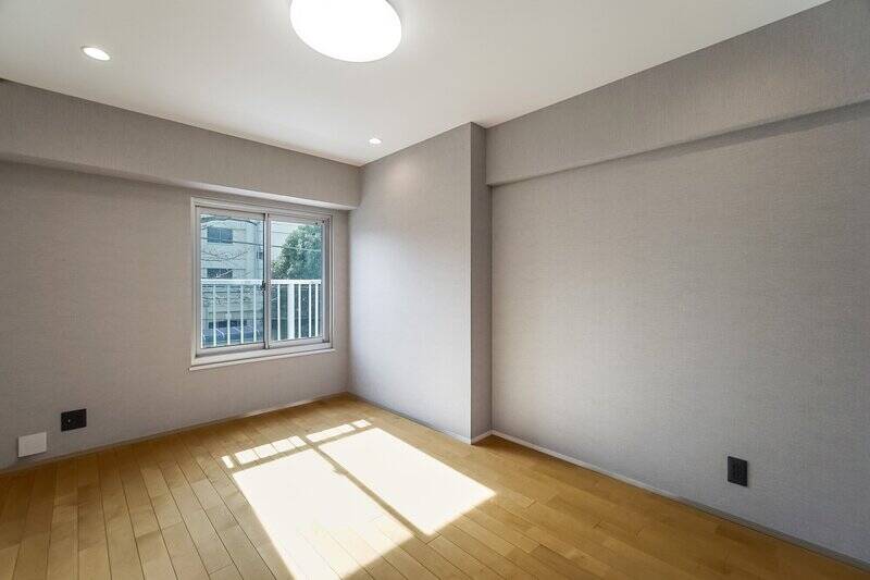 洋室Aも南向きで、ご覧の通りの日当たりのよさ◎ 腰高窓の向こうにはコンパクトな室外機置き場があります。