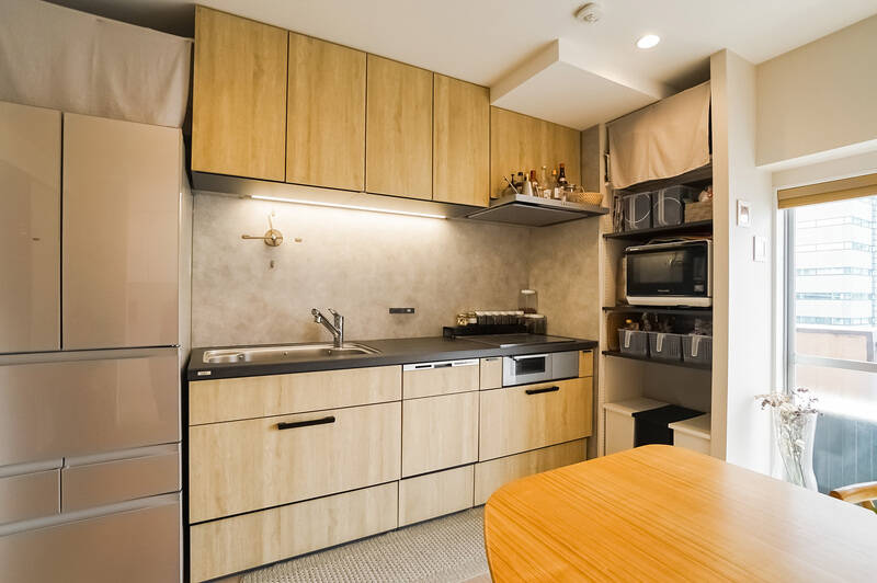 キッチンはLIXILの最上級グレード、「リシェル」。面材は木目調で、空間に馴染むデザインです。天板はセラミックなので、傷がつきにくくお手入れがしやすいところがうれしい。右手には可動棚の収納も備わっています。