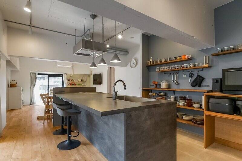 LDKの中心に鎮座するのは、ダークグレーの天板が印象的な大型キッチン。背面にはオープンシェルフが備わっており、お気に入りの器をディスプレイできます。