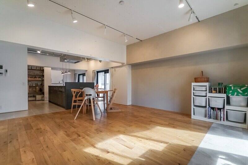 南西と南東の二面バルコニーに面したリビングダイニング。床にはオークの無垢材が張られ、壁の一部は売主さま自ら手がけた塗装仕上げ。光を受けて描く繊細な陰影が、空間に奥行きを与えています。