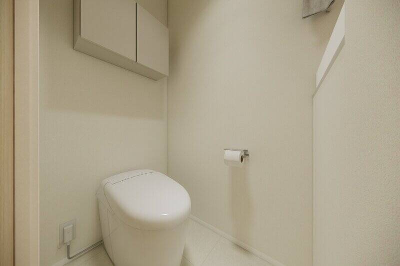 トイレは廊下からアクセスする間取り。シンプルなタンクレス仕様で、独立手洗いカウンターが備わっています。