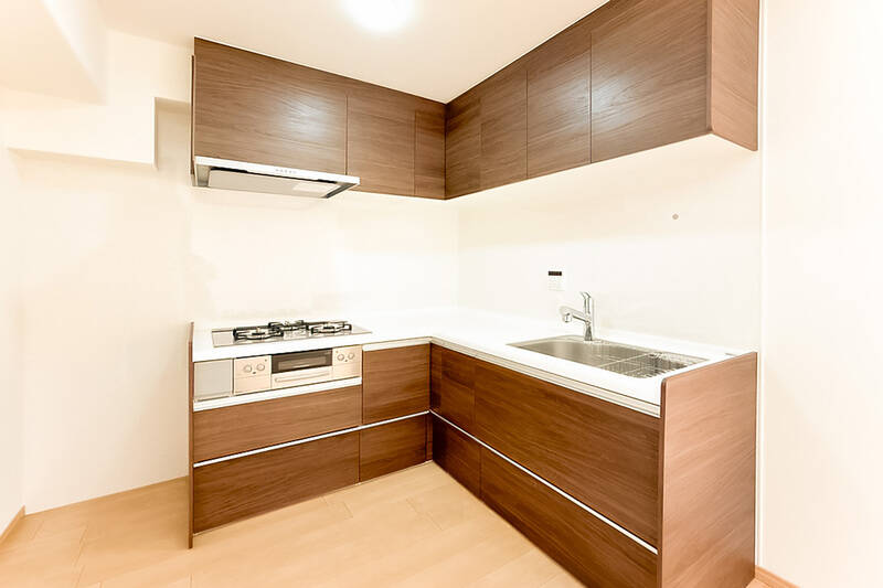 LDから奥まった位置にあるL字型キッチン。上下にたっぷりと収納が用意されています。