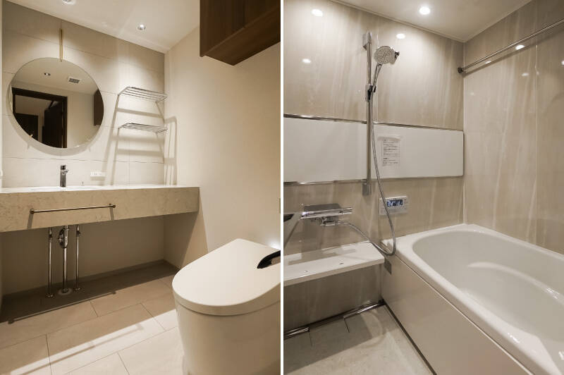 <b>左・</b>洗面台とトイレは2in1の間取り。大きな丸いミラーや、フィオレストーンの天板など、デザイン性の高い造りです。下部に収納として使える広いカウンターを設置予定。／<b>右・</b>バスルームは石調のデザイン。浴室乾燥機が備わっています。