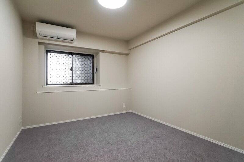 <p>約7.1帖の広さで、すっきりとした四角い形状。腰高窓は共用廊下側に面しており、デザイン性のある格子がほんのりと透けて見えます。こちらも床はカーペット仕上げです。</p>