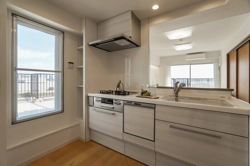 食洗機を完備した対面キッチン。左手のガラス戸を開ければ、すぐそこはルーバルです。料理後の換気もあっという間にできちゃいそうですね。また対面には、冷蔵庫や食器棚を置くためのスペースがしっかりと確保されています。