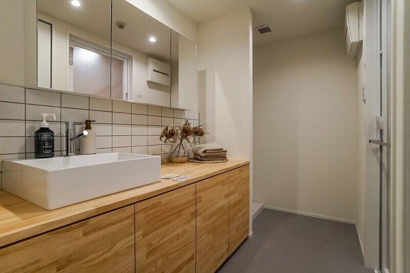 ワイドサイズの洗面化粧台は収納量が豊富。奥には洗濯機置き場があります。