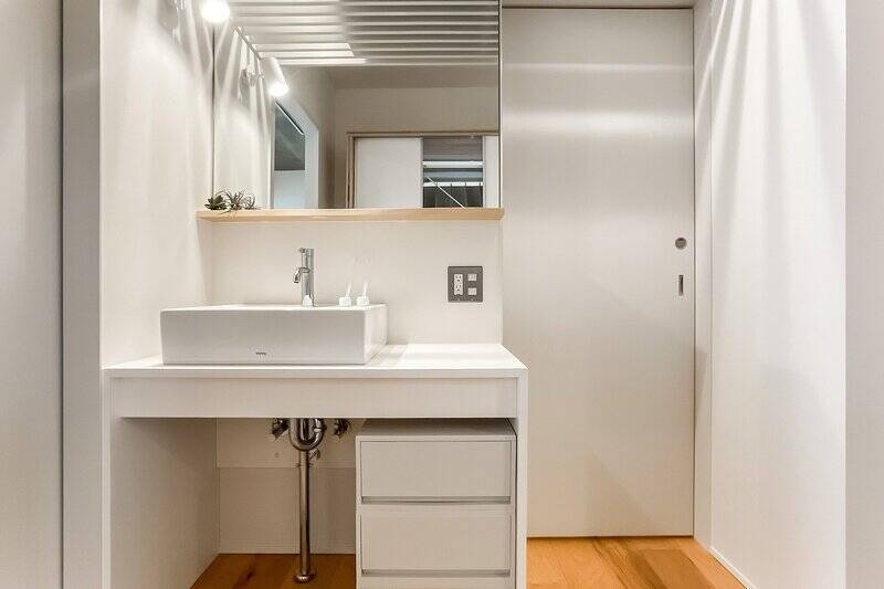 洗面台は廊下に配置。帰宅してすぐに手を洗える衛生面に配慮された設計。右の扉から脱衣室へ。