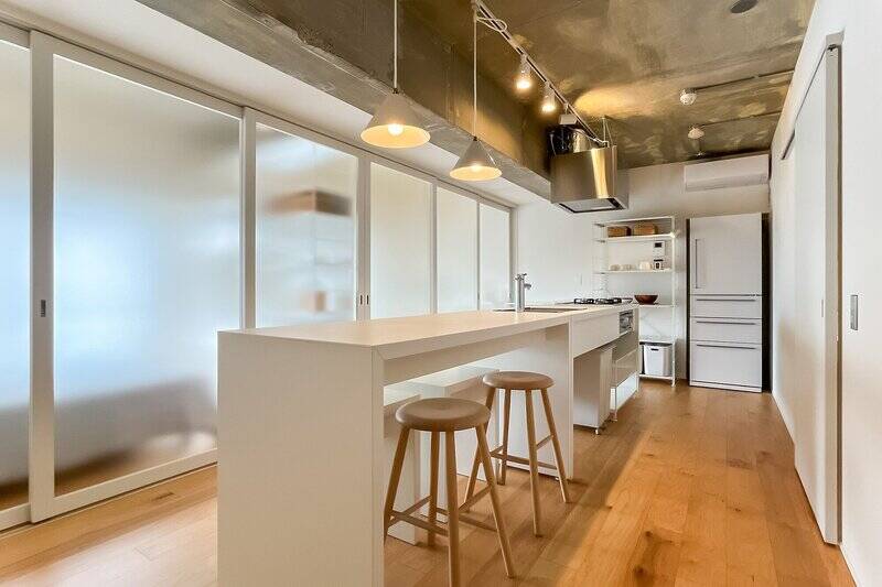 ダイニングキッチン（DK）は約10帖。ダイニングテーブルと連続したキッチンが、暮らしの中心に。半透明の扉を開ければ、ライフスタイルに応じて空間をアレンジできます。