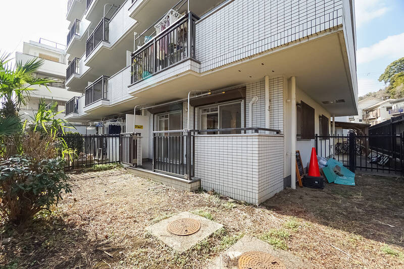 専用庭は住戸を包むようなL字型をしており、約35㎡のゆったりサイズ。取材時は沈丁花の花が咲き始めていてとてもいい香りがしましたよ♡ 右手奥の鉄柵の向こうには、マンションの駐輪場が広がっています。