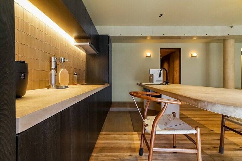 作業スペースだけ床が一段下がり、汚れに強いタイル敷きに。壁面には4口IHクッキングヒーターが備わっています。